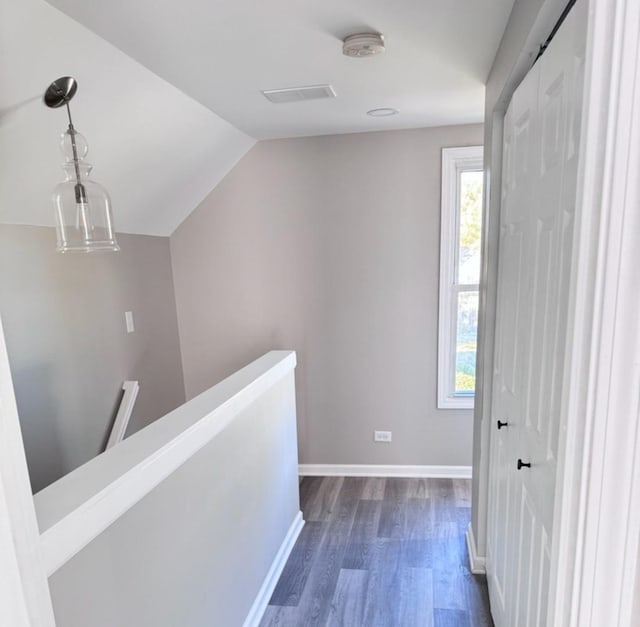 corridor featuring dark hardwood / wood-style flooring and vaulted ceiling