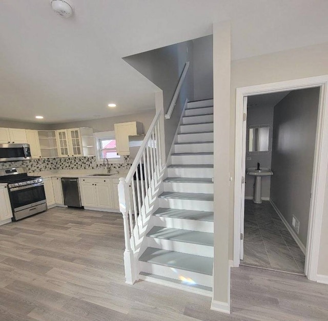 stairs with sink and wood-type flooring