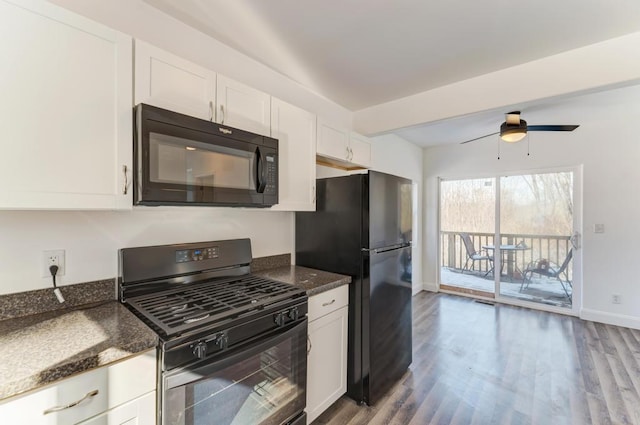 kitchen featuring baseboards, white cabinets, dark stone countertops, wood finished floors, and black appliances