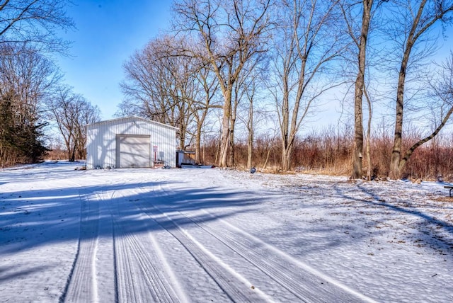 yard covered in snow with a garage and an outbuilding