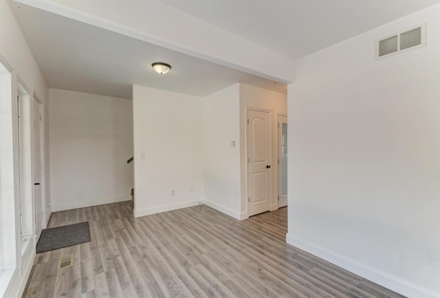 empty room with baseboards, visible vents, and light wood-style flooring