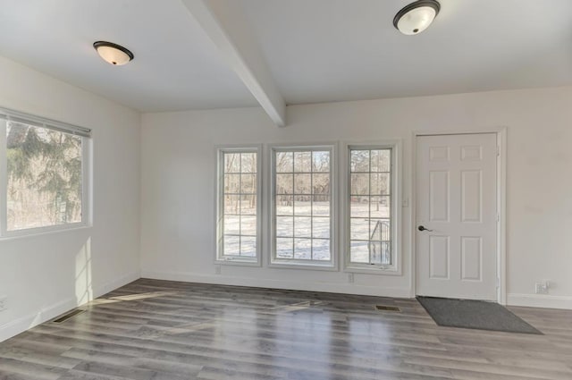 foyer entrance with beamed ceiling, wood finished floors, visible vents, and baseboards