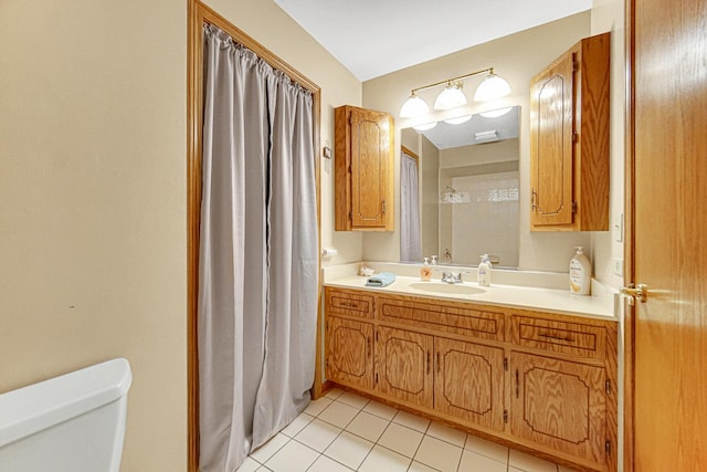 bathroom featuring toilet, vanity, and tile patterned flooring