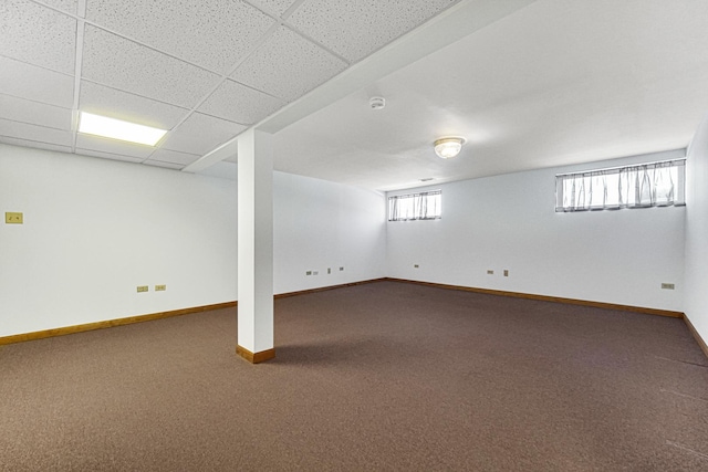 basement featuring a paneled ceiling and carpet flooring