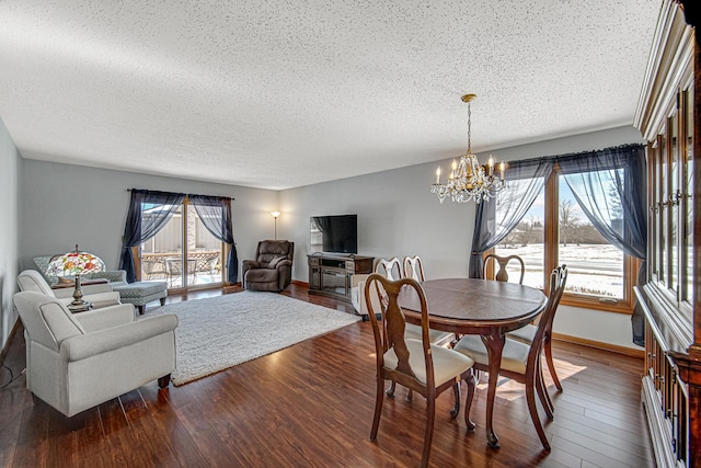 dining space featuring a notable chandelier, dark wood-type flooring, and a textured ceiling