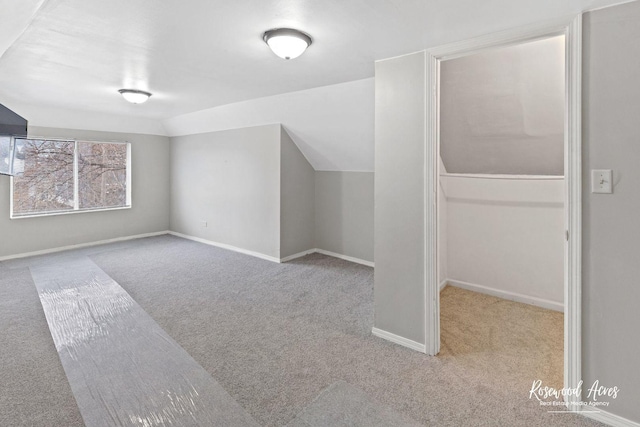 bonus room featuring vaulted ceiling and light carpet