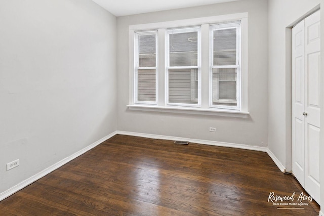 spare room with dark wood-type flooring