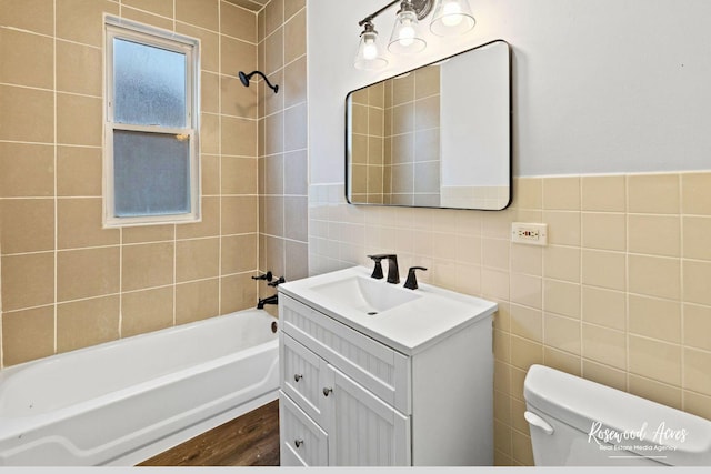 full bathroom with wood-type flooring, tile walls, tiled shower / bath combo, vanity, and toilet