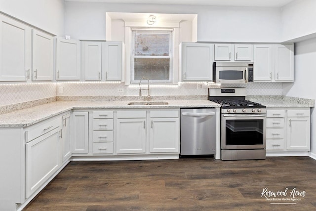 kitchen featuring sink, light stone counters, dark hardwood / wood-style floors, stainless steel appliances, and white cabinets