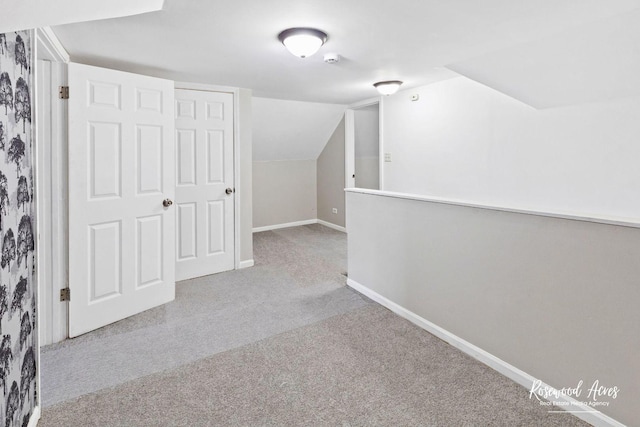 additional living space with light colored carpet and lofted ceiling