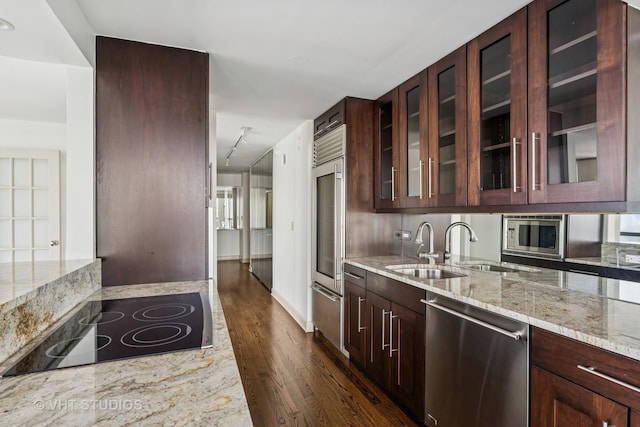 10 E Ontario St Unit 4308, Chicago, IL 60611 - kitchen featuring built in appliances, dark wood-type flooring, light stone countertops, glass insert cabinets, and a sink