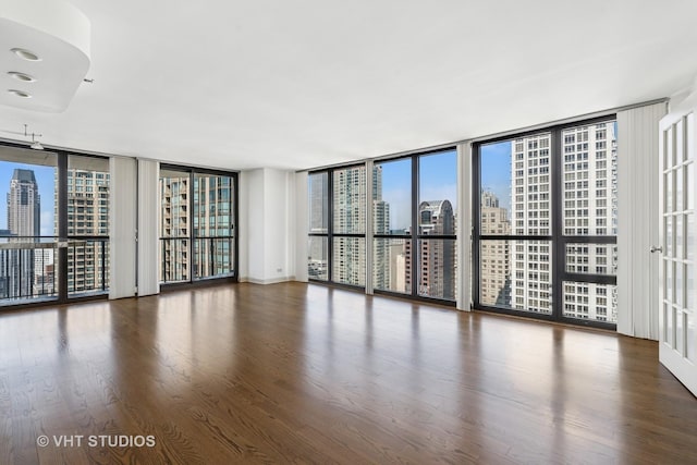 10 E Ontario St Unit 4308, Chicago, IL 60611 - unfurnished room featuring floor to ceiling windows, a city view, healthy amount of natural light, and wood finished floors