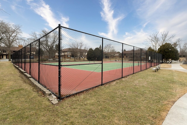 view of tennis court featuring a yard