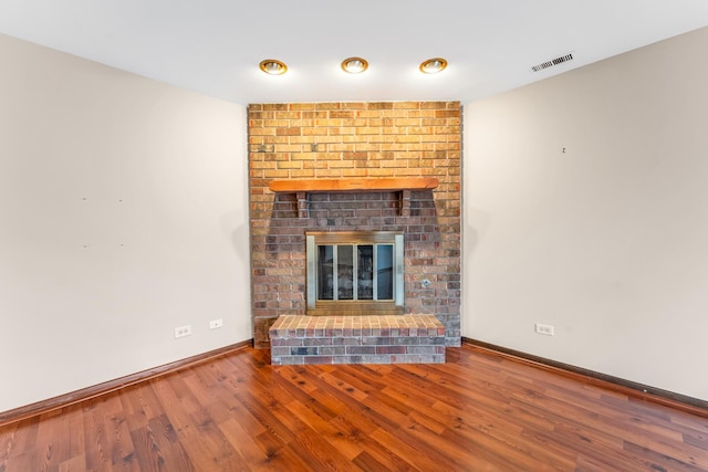 unfurnished living room featuring wood-type flooring and a fireplace