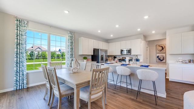 dining area with stacked washer and dryer, dark hardwood / wood-style flooring, and sink