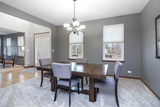 dining space with an inviting chandelier, light wood-type flooring, and a wealth of natural light