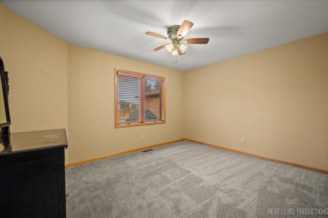 spare room with ceiling fan and light colored carpet