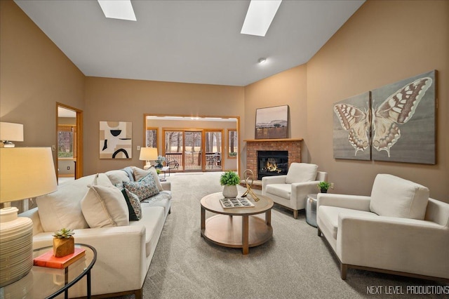 living room with a brick fireplace, carpet floors, high vaulted ceiling, and a skylight