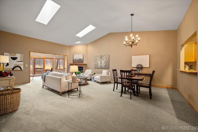 carpeted living room featuring an inviting chandelier, a skylight, high vaulted ceiling, and a brick fireplace