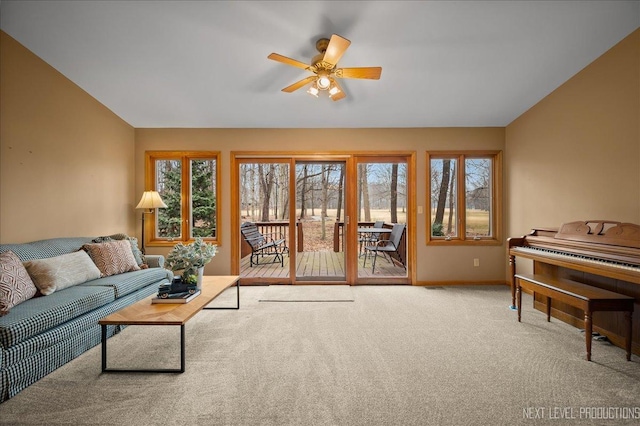 carpeted living room with lofted ceiling, plenty of natural light, and ceiling fan