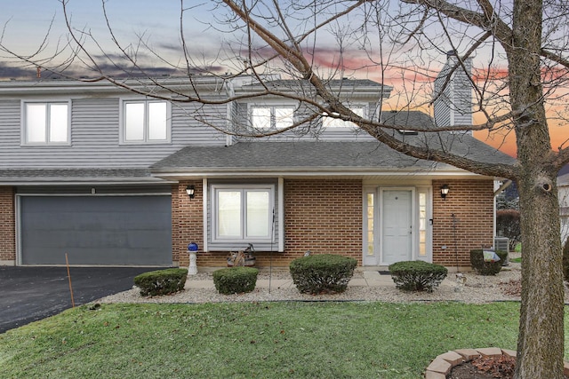 front of property featuring a garage and a yard