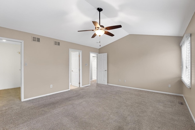 empty room featuring lofted ceiling, light colored carpet, and ceiling fan