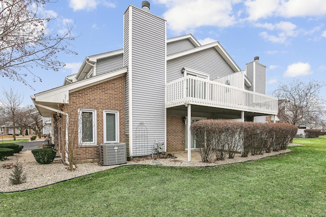 rear view of house featuring cooling unit, a lawn, and a deck