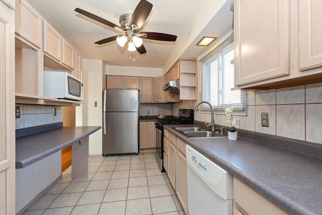 kitchen with appliances with stainless steel finishes, light tile patterned floors, sink, and decorative backsplash