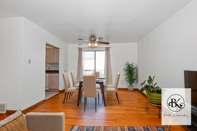 dining area with light wood-type flooring and ceiling fan