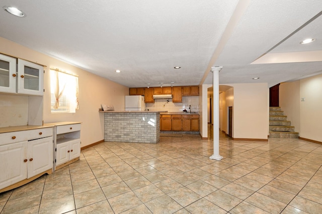 kitchen with white refrigerator, sink, backsplash, ornate columns, and light tile patterned flooring