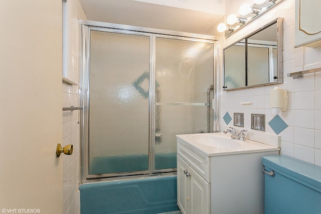 full bathroom with toilet, shower / bath combination with glass door, tile walls, vanity, and decorative backsplash