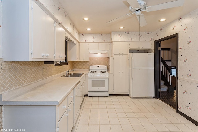 kitchen with sink, white appliances, light tile patterned floors, ceiling fan, and white cabinets