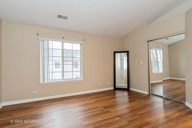 unfurnished room with lofted ceiling and hardwood / wood-style floors