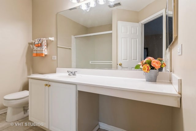 bathroom featuring vanity, a shower with shower door, tile patterned floors, and toilet