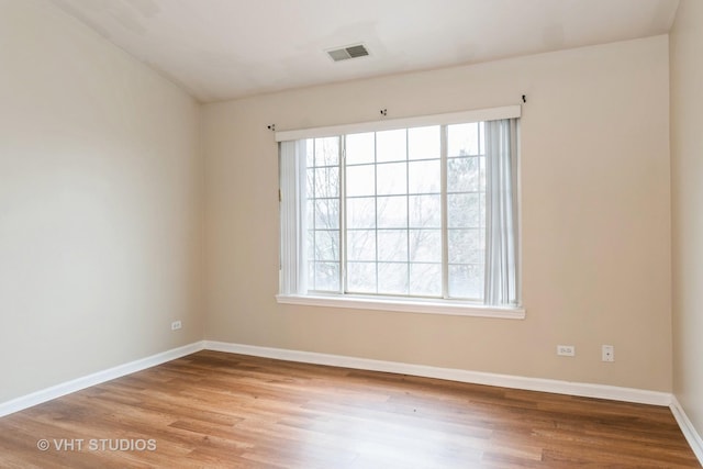 empty room with light hardwood / wood-style flooring and plenty of natural light