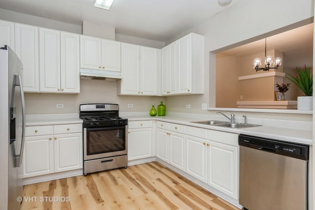 kitchen with sink, decorative light fixtures, white cabinets, and appliances with stainless steel finishes