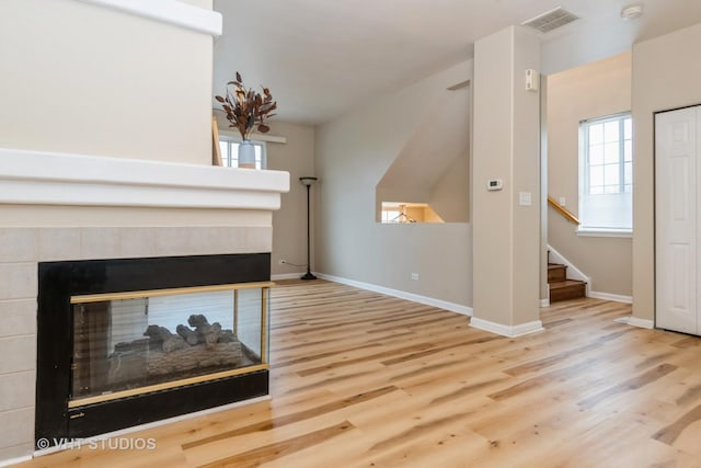 unfurnished living room featuring plenty of natural light, hardwood / wood-style floors, and a fireplace