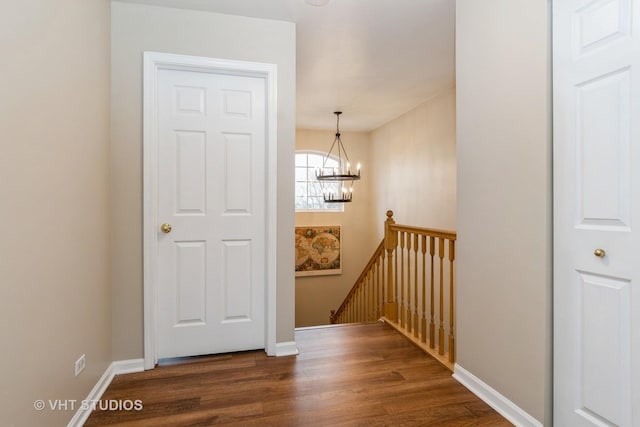 staircase featuring hardwood / wood-style floors and a notable chandelier