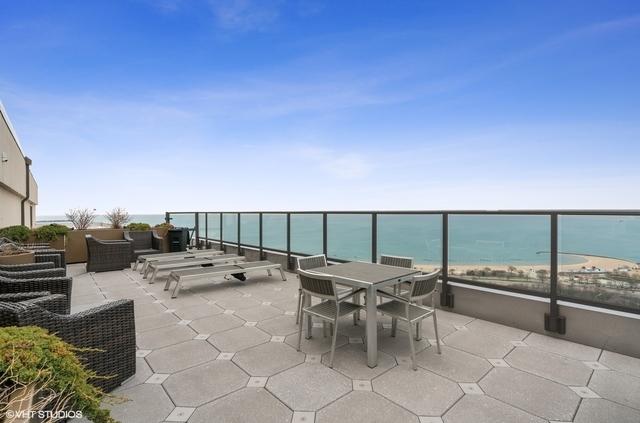 view of patio / terrace featuring a view of the beach, a balcony, and a water view