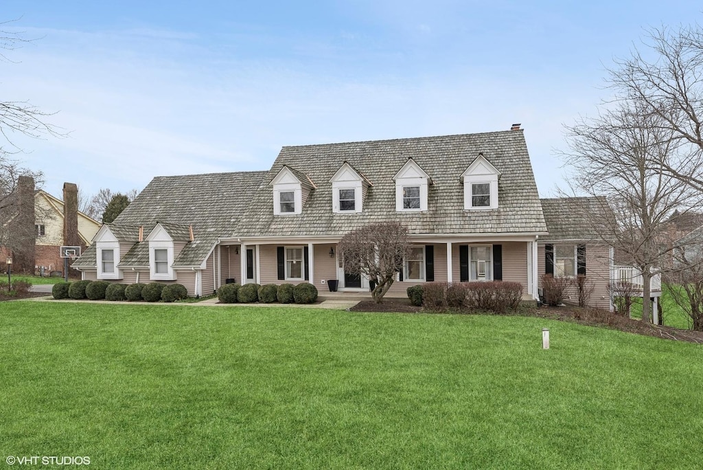 cape cod home featuring covered porch and a front yard