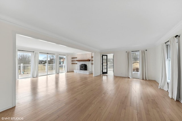 unfurnished living room with ornamental molding, a fireplace, and light hardwood / wood-style floors