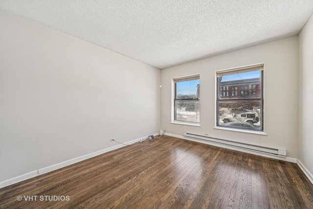 unfurnished room with a baseboard heating unit, dark wood-type flooring, a textured ceiling, and baseboards