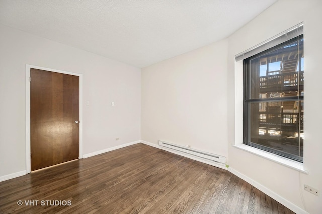 empty room featuring a baseboard radiator, a textured ceiling, baseboards, and dark wood-style flooring