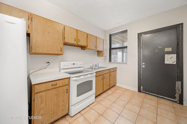 kitchen featuring white appliances, light tile patterned floors, baseboards, light countertops, and a sink