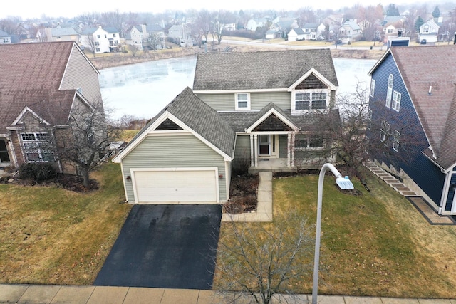 view of front facade featuring a garage, a front yard, and a water view