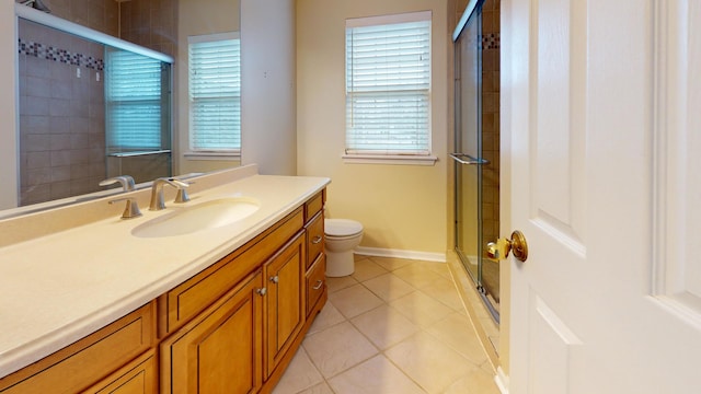 bathroom featuring tile patterned floors, vanity, toilet, and a shower with shower door