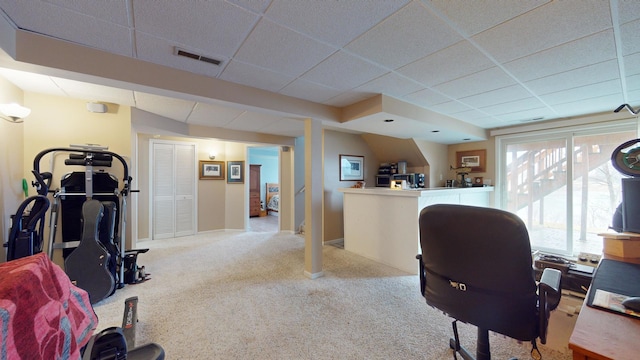 office space featuring a paneled ceiling and light carpet