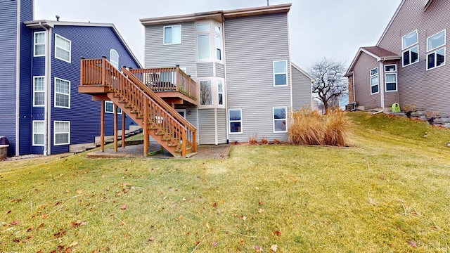 back of property featuring a wooden deck and a lawn