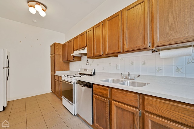 kitchen with sink, gas range gas stove, tasteful backsplash, light tile patterned floors, and stainless steel dishwasher