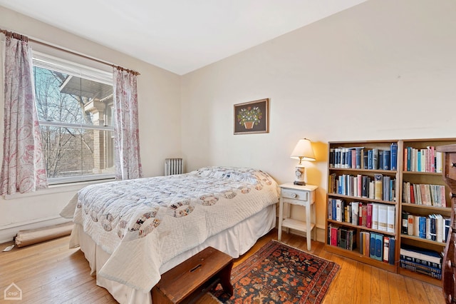 bedroom with hardwood / wood-style floors and radiator